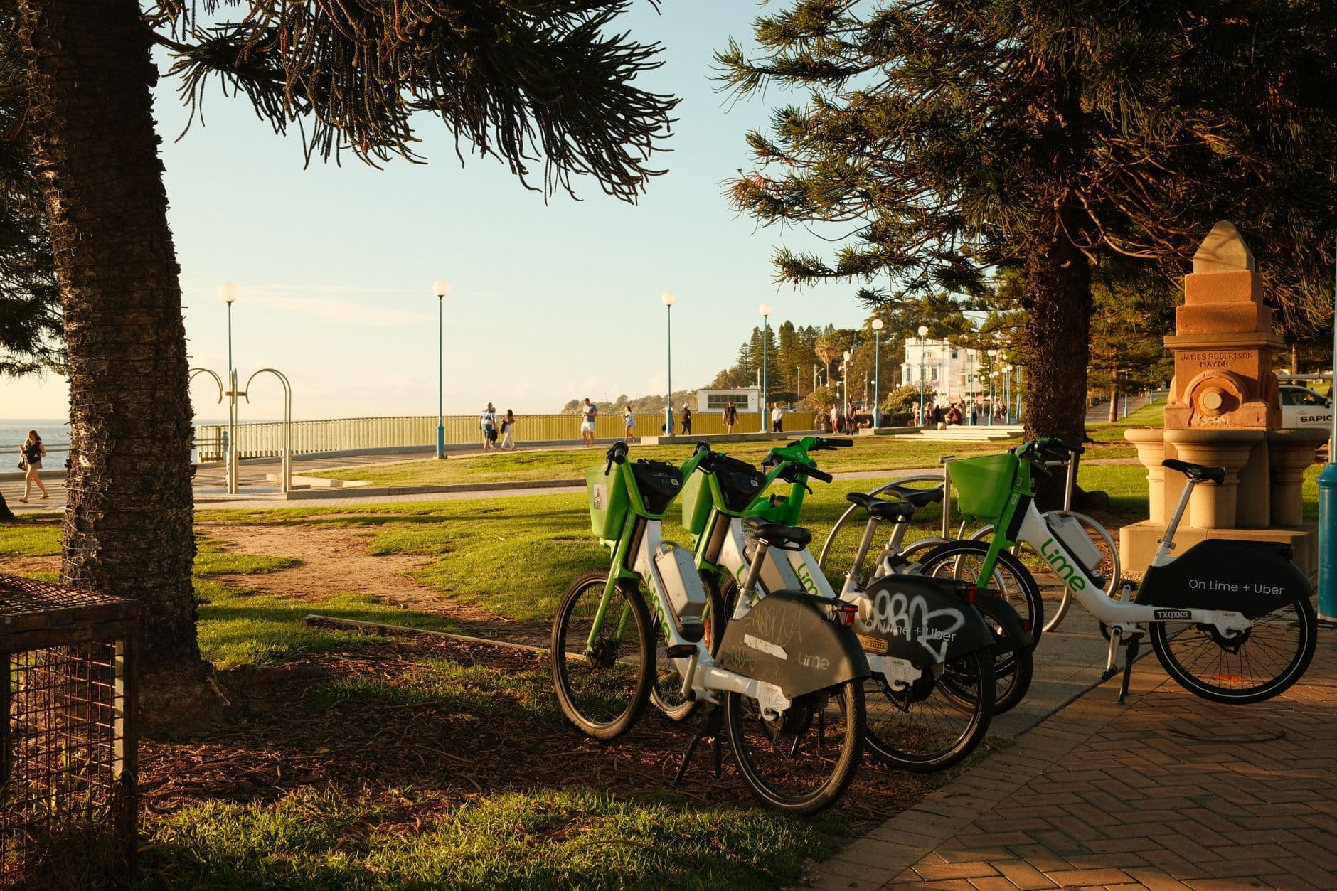 Lime bikes parked by a scenic coastal pathway in Sydney. Perfect for eco-friendly travel.